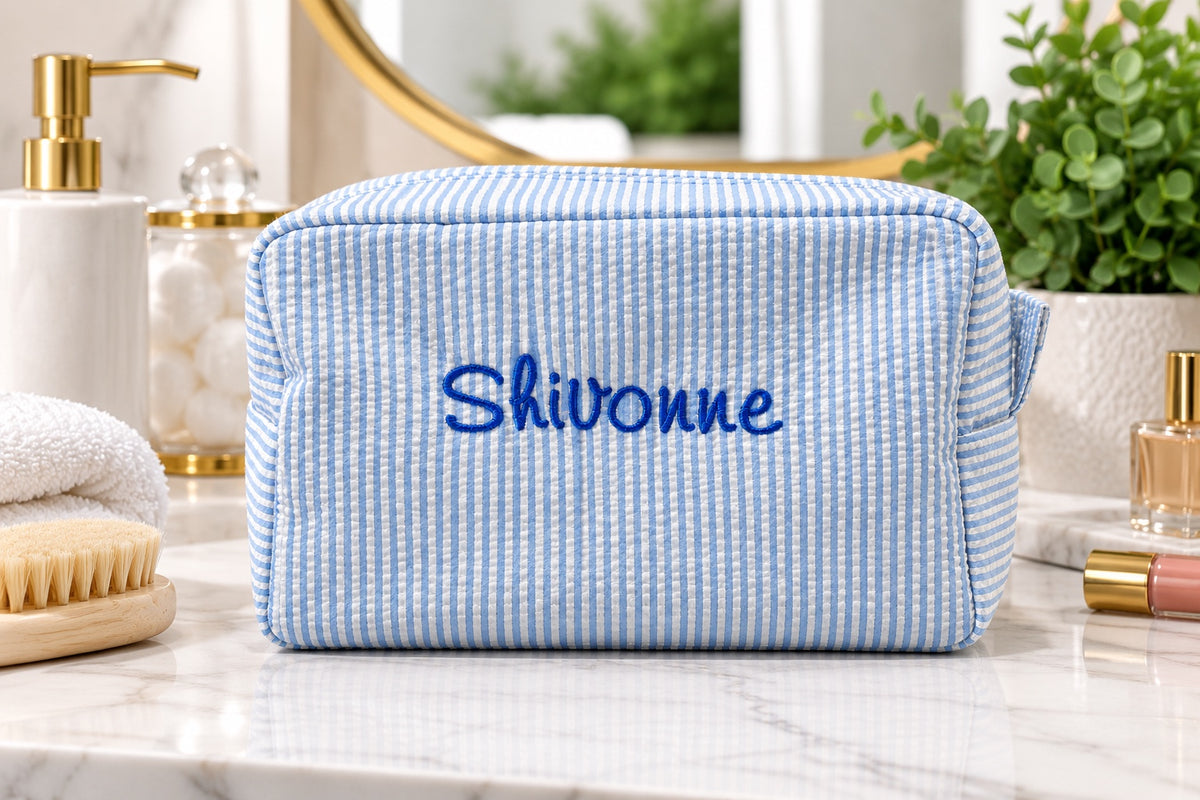 Personalized embroidered seersucker bag styled on a vanity